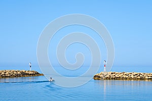 A fisherman is going fishing on a boat to the sea.