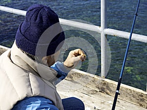 Fisherman grafts into the hook a Korean worm