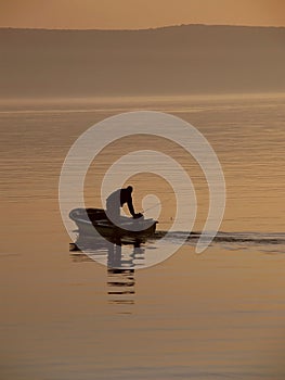 Fisherman in the haze at sea