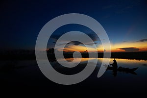 Fisherman on his traditional boat at sunrise