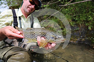 Fisherman holding brown trout