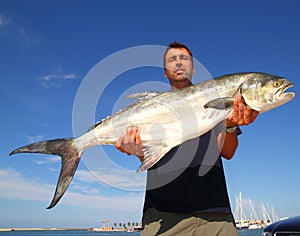 Fisherman holding catch Garrick Lichia Amia