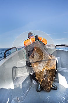 Fisherman holding the tail of a huge fish. vertical shot