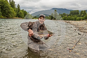 A fisherman holding a huge Taimen trout caught on a river in Mongolia, Moron, Mongolia photo