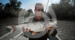 Fisherman holds the Asp fish