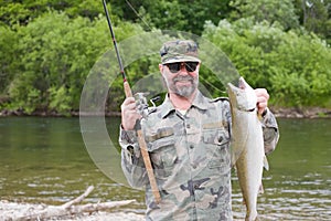 Fisherman holds caught pink salmon