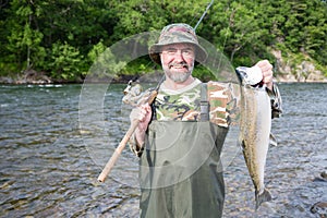 Fisherman holds caught pink salmon.