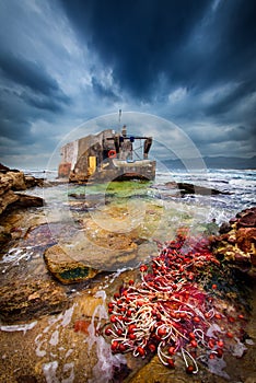 Fisherman house on the sea with red fishnet, in Porto Paglia on the south of Sardinia, Gonnesa.