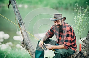 Fisherman man angler on river or lake with fishing rod.
