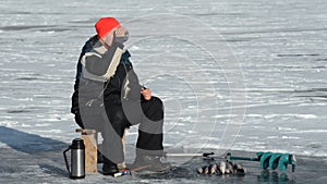 Fisherman is a man in winter fishing.