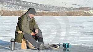 Fisherman is a man in winter fishing.