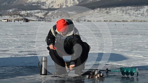 Fisherman is a man in winter fishing.