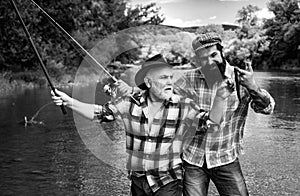 Fisherman men friends and trophy trout. Father and son fishing. Generations men fishing in river.