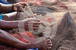Fisherman mending nets. Burgundy, black, white, gray