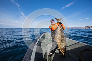 Fisherman in the middle of the sea with a huge fish