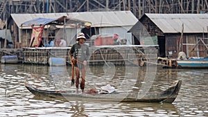 Fisherman with net in boat, Tonle Sap, Cambodia