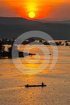 Fisherman paddling rowboat to fishing with sunset, Silhouette