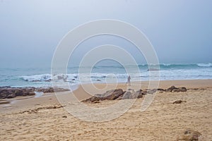 Fisherman person sihouette with fishing rod on empty beach