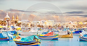 Fisherman port village in Marsaxlokk Malta. Mediterranean traditional retro colorful boats luzzu on summer