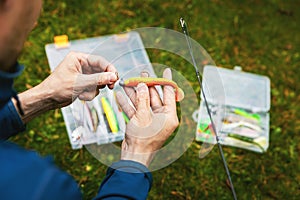 Fisherman putting on soft plastic fishing bait