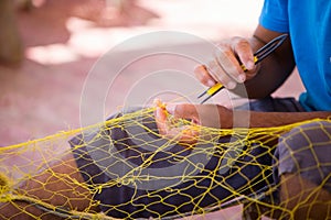 Fisherman repairing fishing net