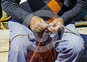 Fisherman repairs the fishing net