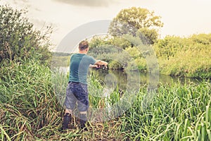 Fisherman on the river at dawn in summer