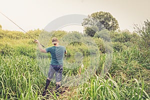 Fisherman on the river at dawn in summer