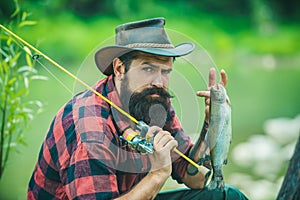 Fisherman with rod and fish. Keep calm and fish on.Fishing on the lake. Mature man fly fishing. Man fishing on river