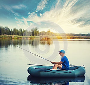 A fisherman in a rubber boat is fishing on the lake