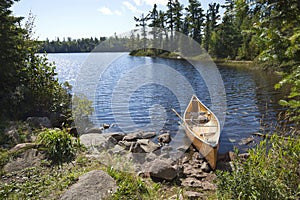 A fisherman's canoe on rocky shore in northern Minnesota lake