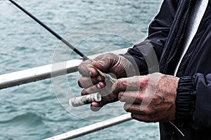 Close-up of a fisherman`s hands using his fishing gear