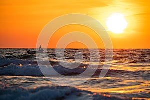 Fisherman sailing with his boat on beautiful sunrise over the sea