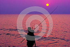 Fisherman by the sea at sunset