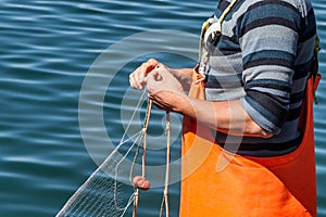 Fisherman sewing nets photo