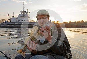 Fisherman is showing a walleye