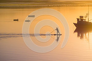 Fisherman silhouette. Sunrise in the harbour of Quellon in Chiloe Island. Patagonia in Chile