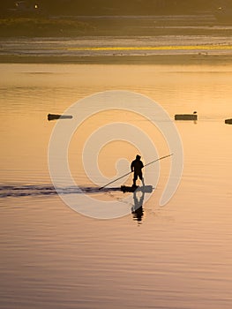 Fisherman silhouette. Sunrise in the harbour of Quellon in Chiloe Island. Patagonia in Chile