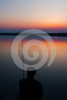 Fisherman silhouette in sunset.