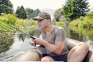 Fisherman sits in a boat with a spinning