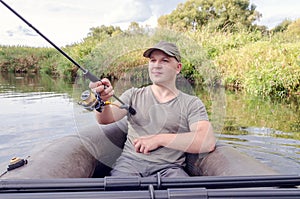 Fisherman sits in a boat with a spinning