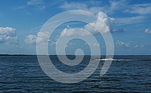 Fisherman speeding along on a lake