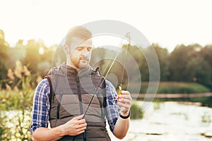 Fisherman with a spinning rod and bait (lure, wobbler) catching