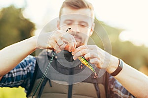 Fisherman with a spinning rod and bait (lure, wobbler) catching