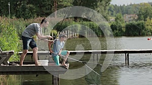 Fisherman with spinning rod catching fish on lake