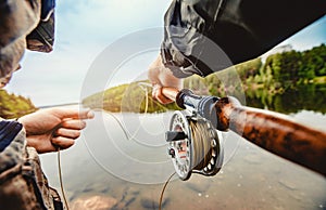 Fisherman spool of rope using rod fly fishing in river