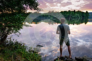 Fisherman standing on the banks of Vltava at beautiful sunset, fishing concept