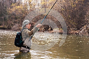 Fisherman standing in river when fishing for grayling photo