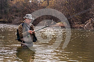 Fisherman standing in river when fishing for trout