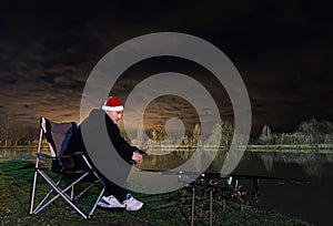 Fisherman in Starry Night With santa hat looking on rods, patience